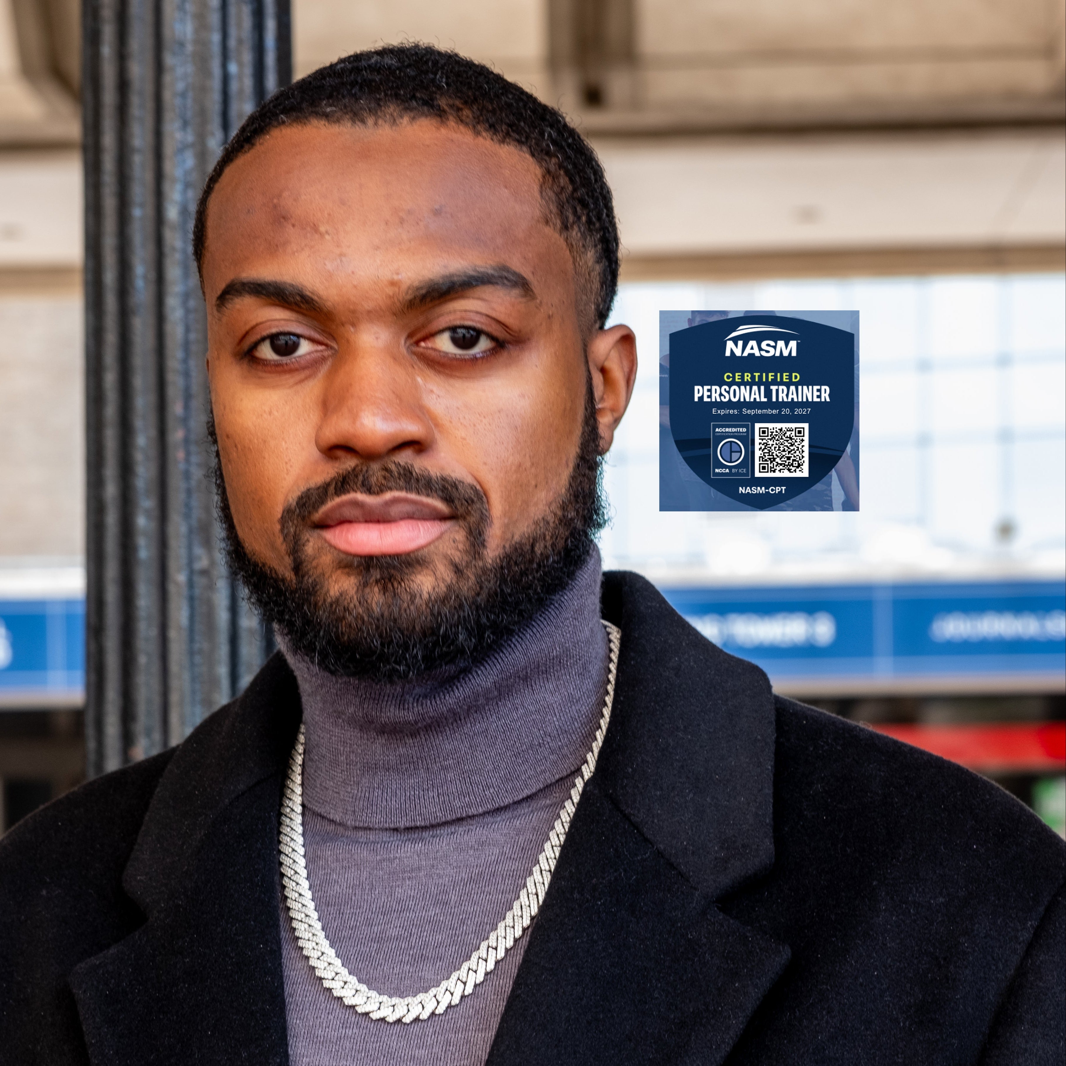 Man wearing a dark coat and gray turtleneck with a NASM Certified Personal Trainer badge in the corner.